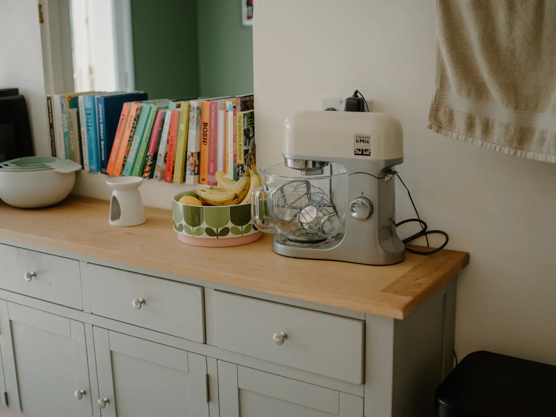 A bright home kitchen with a stand mixer and cookbooks
