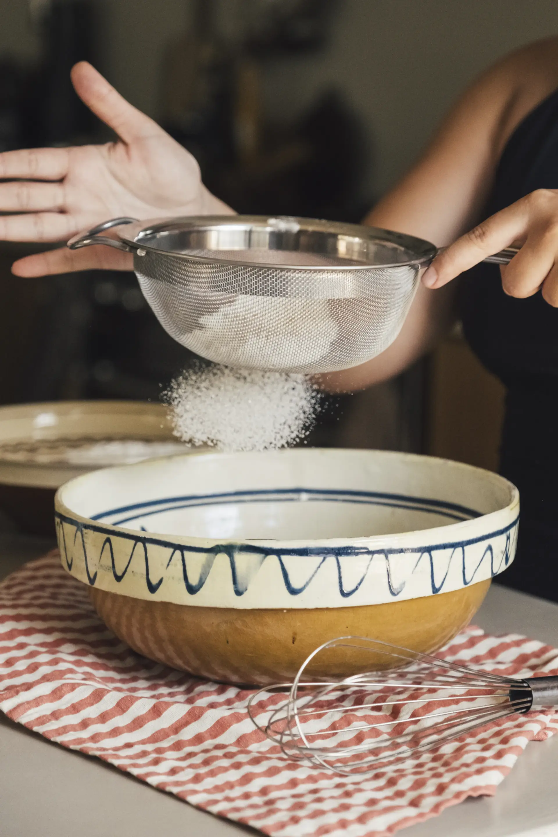 Flour being sifted into a mixing bowl